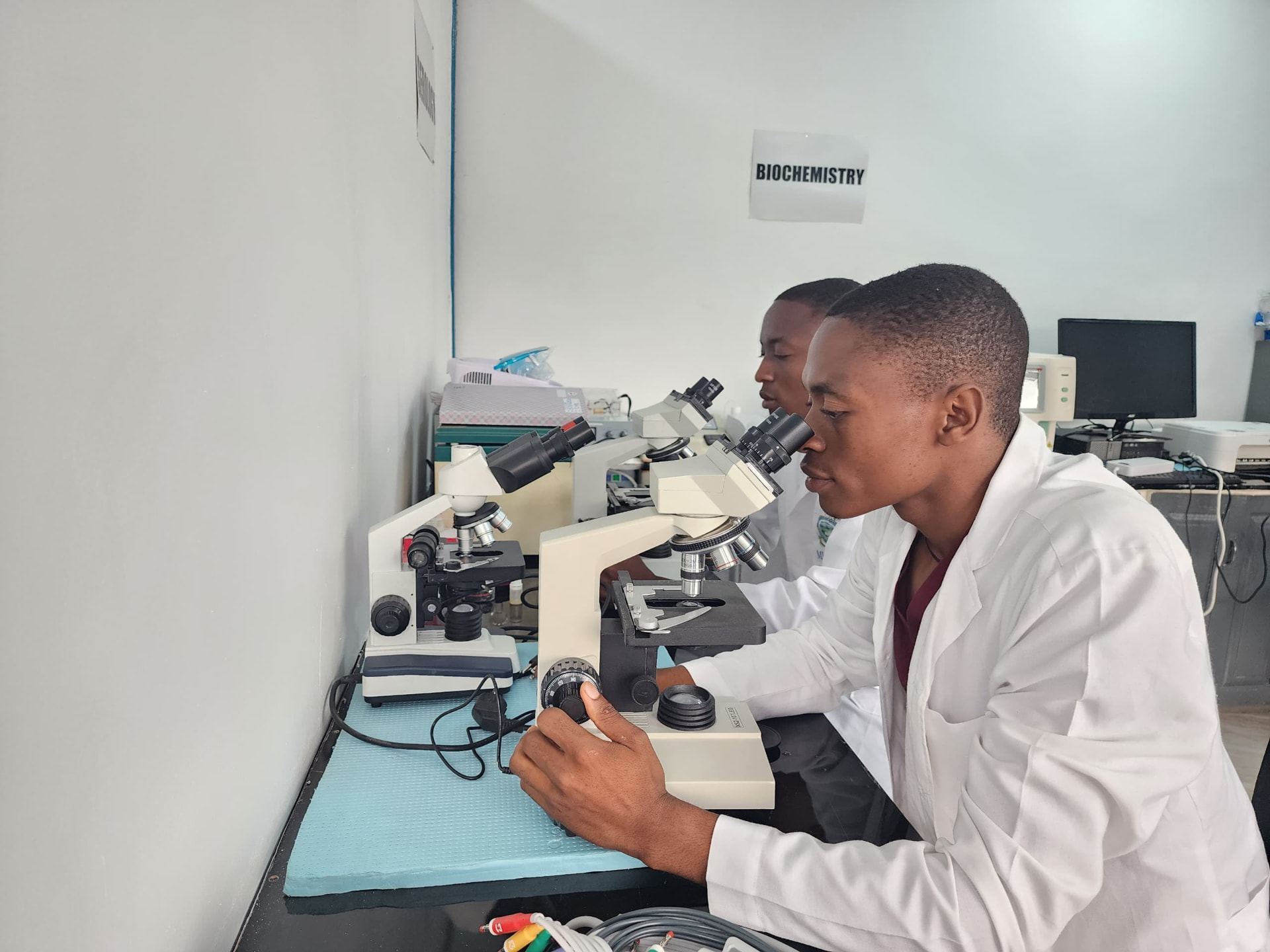 Laboratory scientists examining samples under microscopes at Vision Medical Diagnostic Center